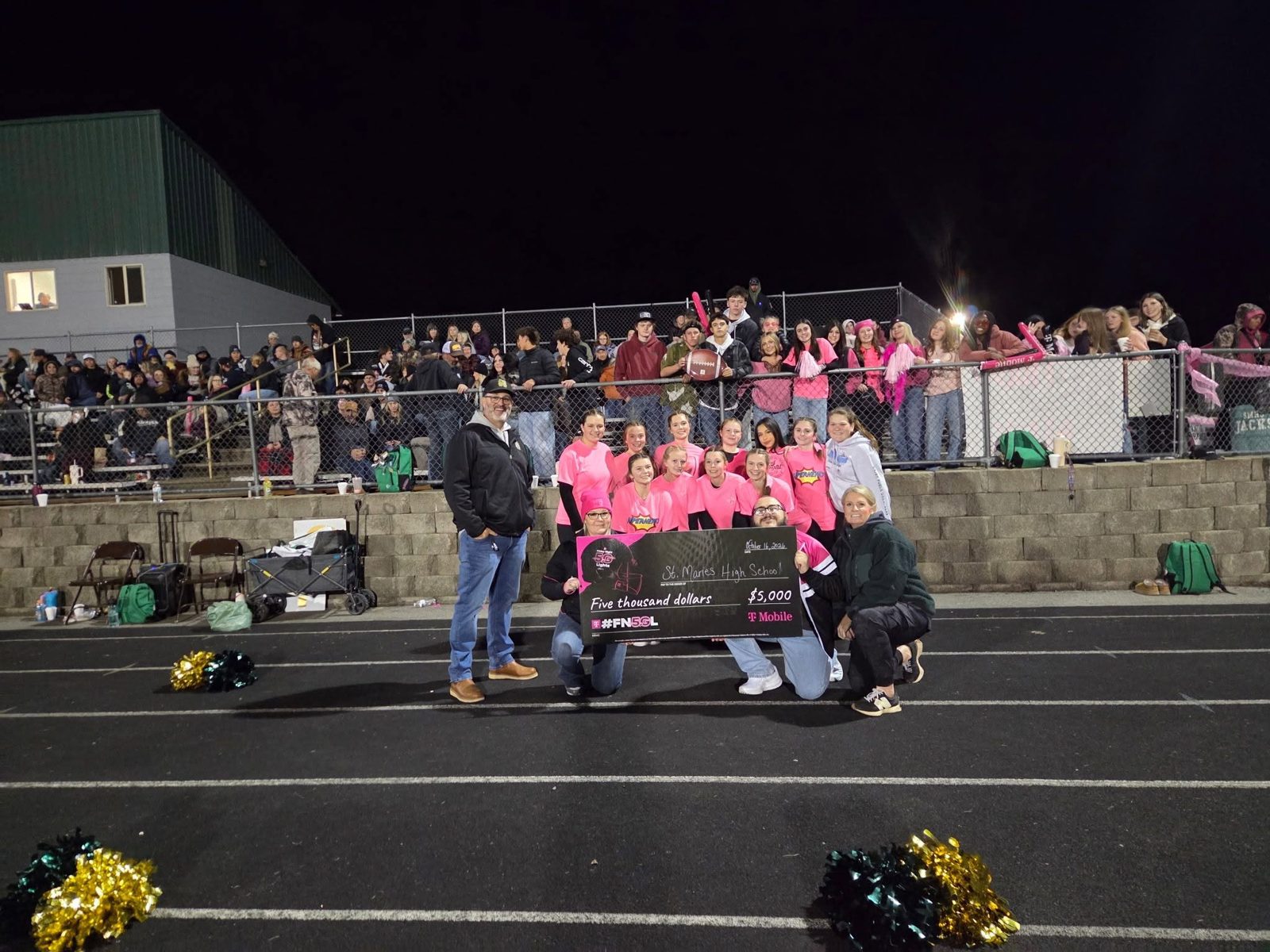 Pink-out night at the St. Maries football field with a fundraiser check presentation